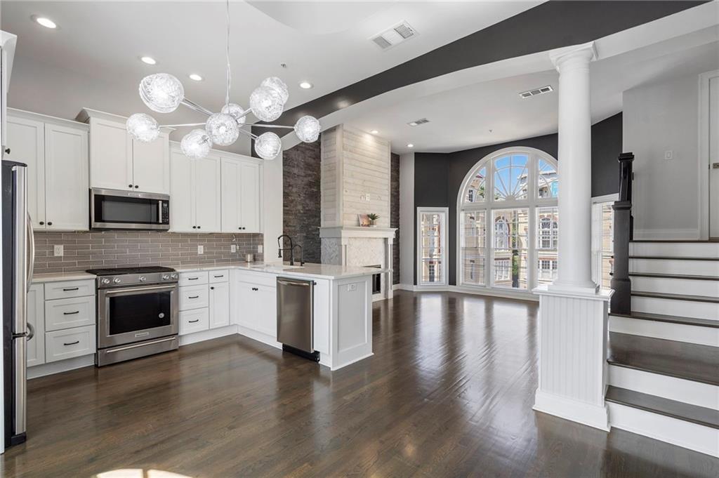 3541 Roswell Road Northeast, Unit 4 Atlanta, GA 30305 - Photo 27 of 45 a large kitchen with white cabinets and stainless steel appliances