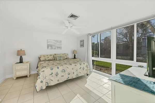 a bedroom with a bed and a large window