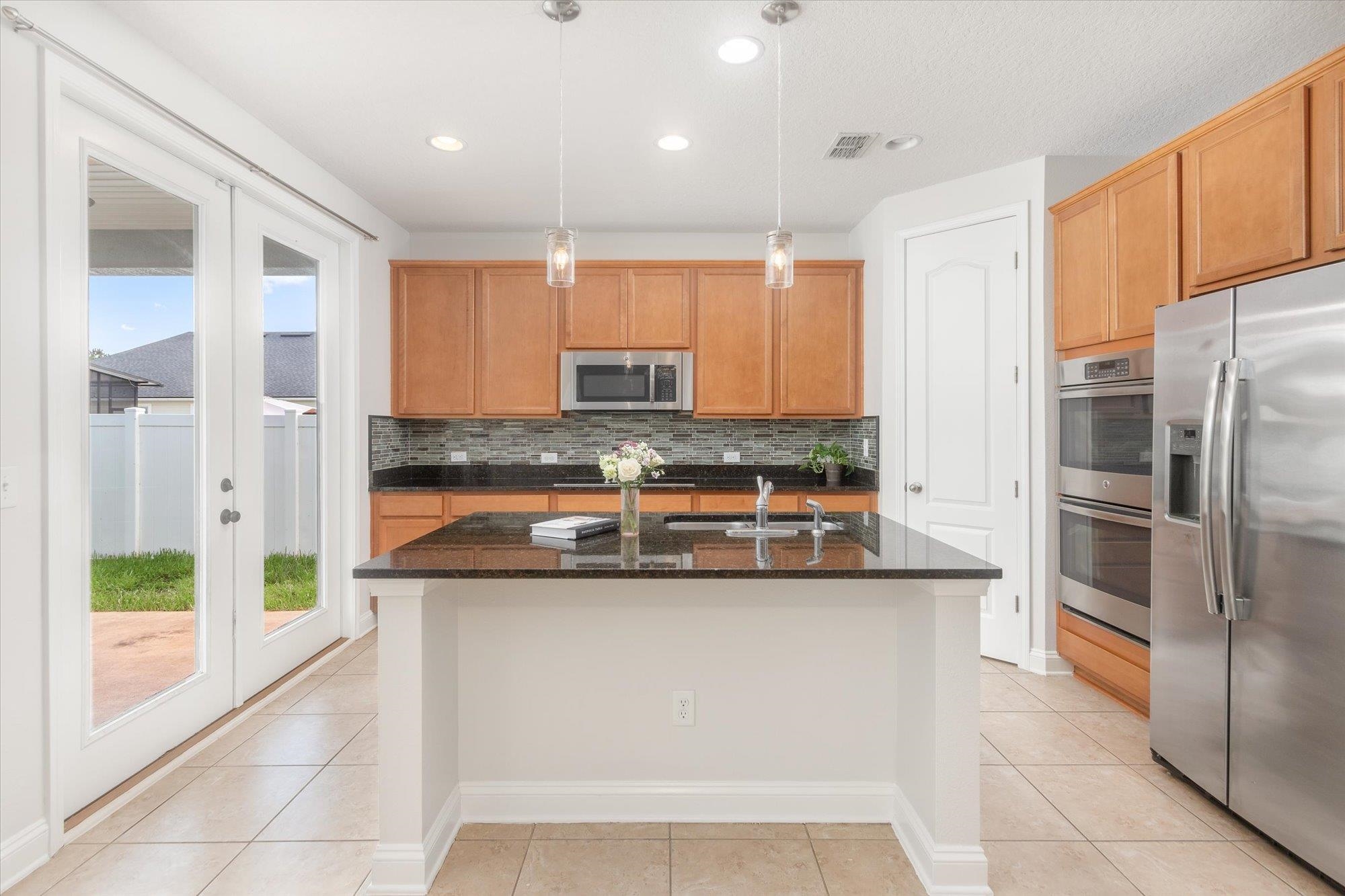 70 Quartz Place St. Augustine, FL 32086 - Photo 6 of 78 a kitchen with stainless steel appliances granite countertop a refrigerator a stove and a sink