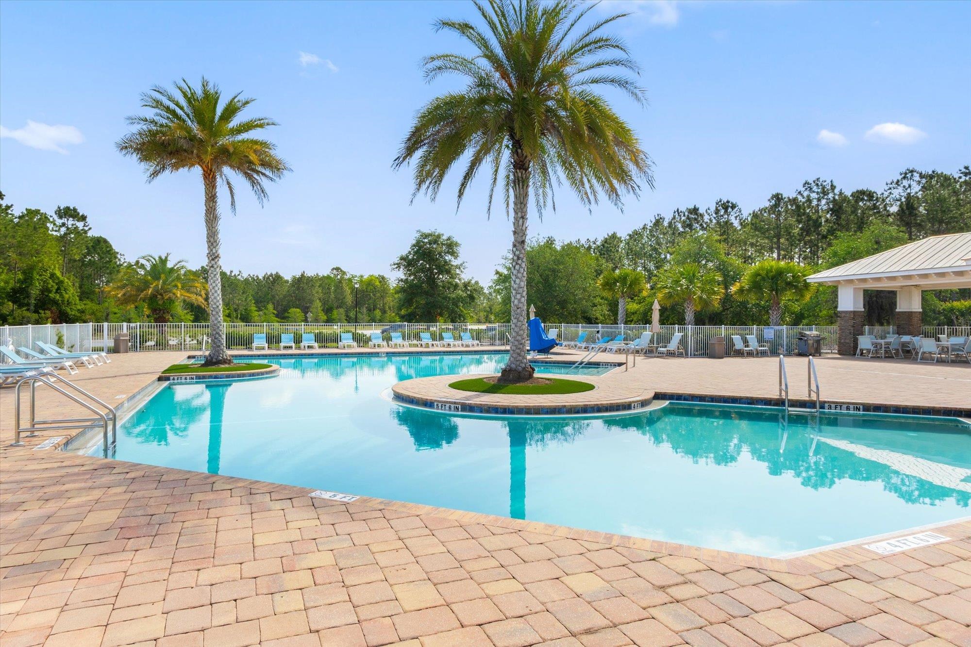 70 Quartz Place St. Augustine, FL 32086 - Photo 69 of 78 a view of a swimming pool with a lounge chair and palm trees