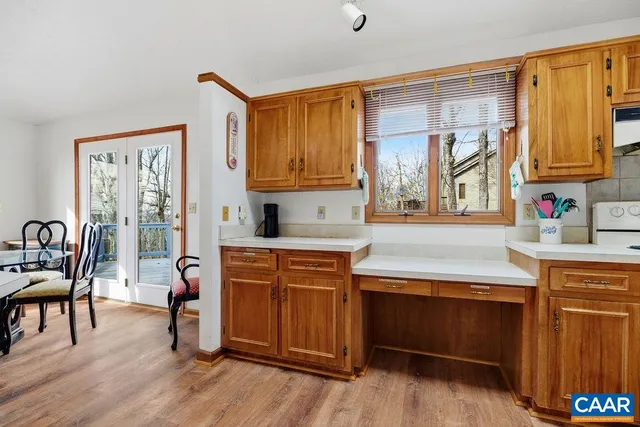 a kitchen with stainless steel appliances granite countertop wooden cabinets a dining table and chairs