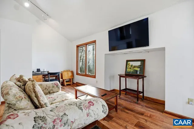 a bedroom with a bed a flat screen tv and a couch