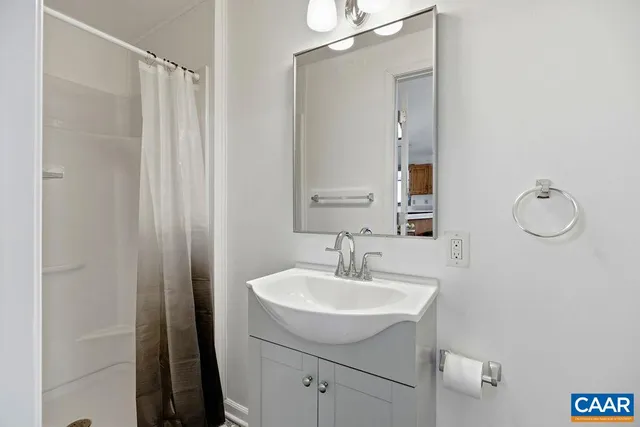 a bathroom with a sink a mirror and shower