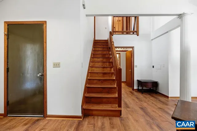 a view of a hallway with wooden floor and stairs
