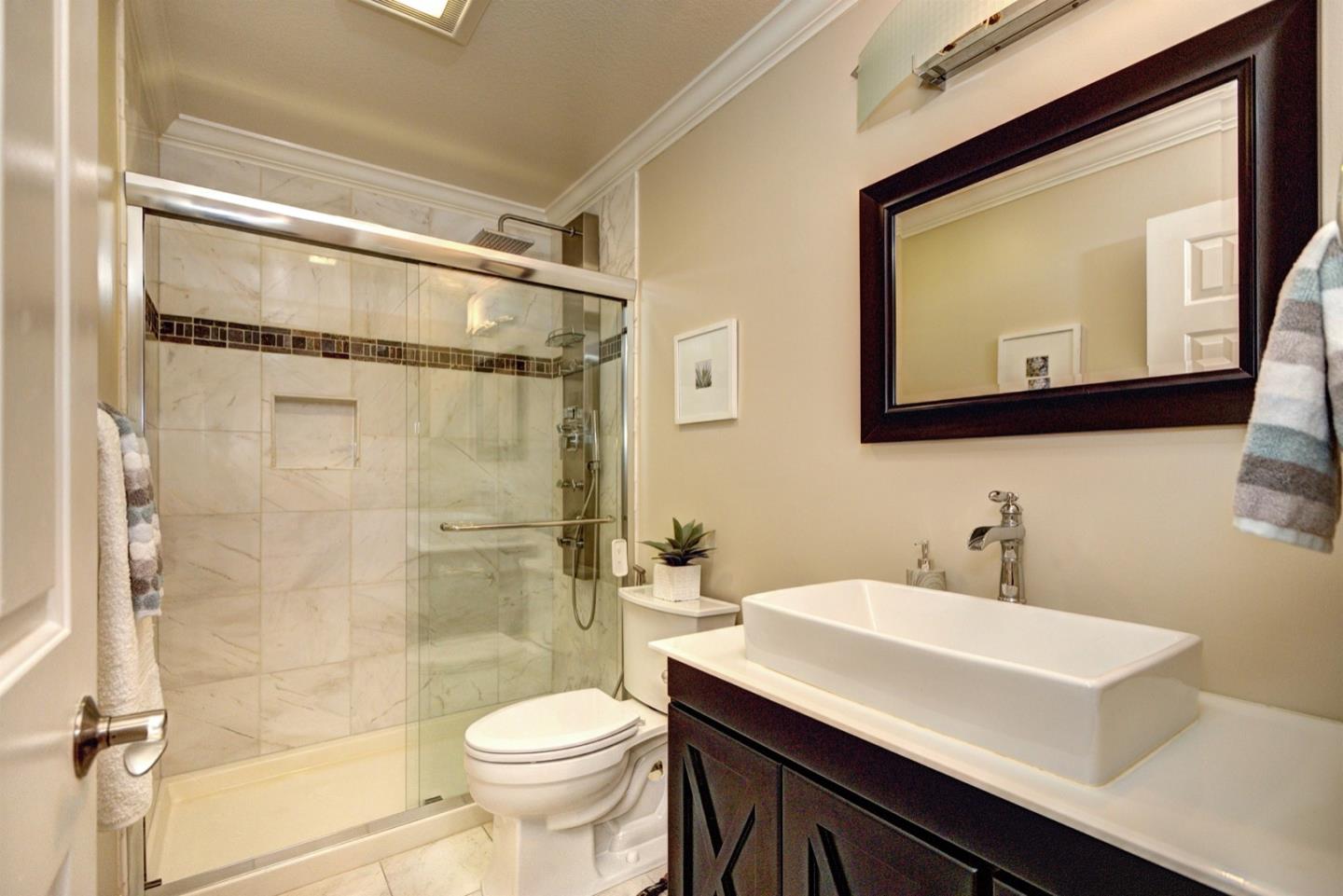 10171 Carmen Road Cupertino, CA 95014 - Photo 22 of 42 a bathroom with a sink mirror vanity and toilet