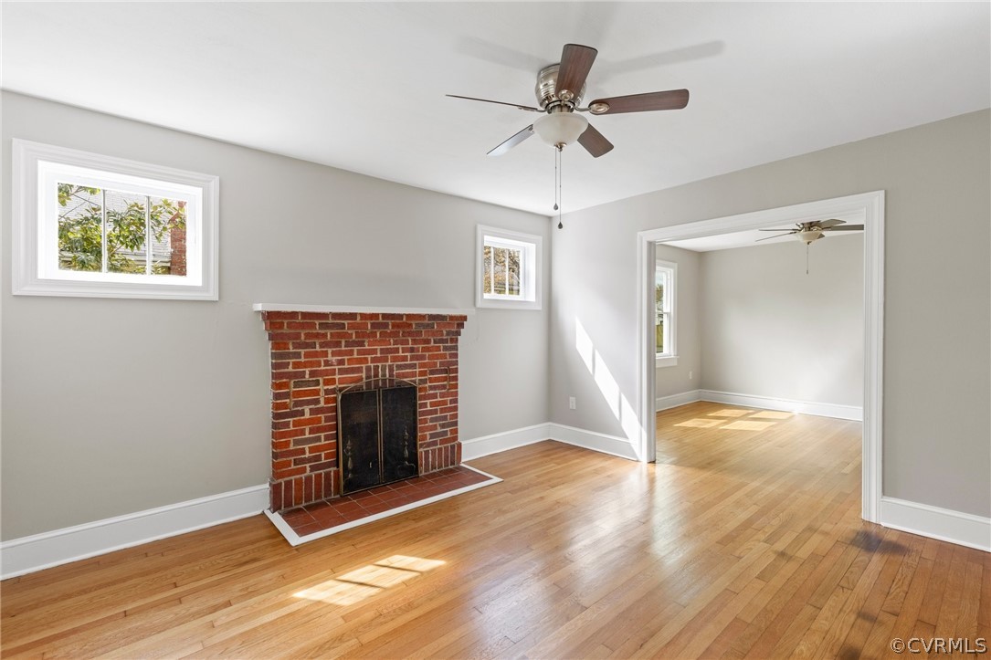 3510 East River Road Petersburg, VA 23803 - Photo 5 of 19 an empty room with wooden floor fireplace and windows