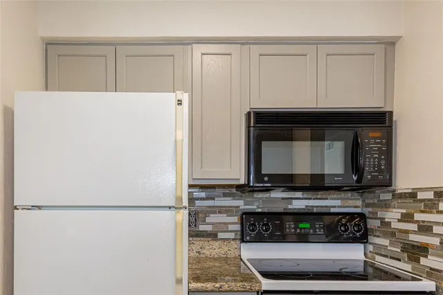 a kitchen with refrigerator and microwave