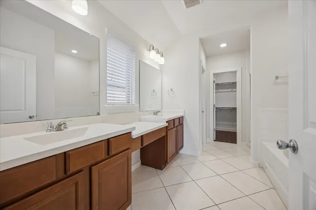 a large bathroom with a granite countertop sink mirror and bathtub