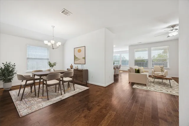 a living room with furniture dining table and a large window
