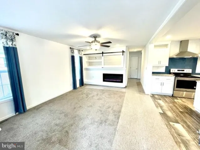 a living room with stainless steel appliances kitchen island granite countertop a sink and a refrigerator