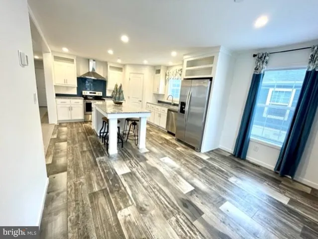 a kitchen with stainless steel appliances granite countertop a refrigerator sink and microwave