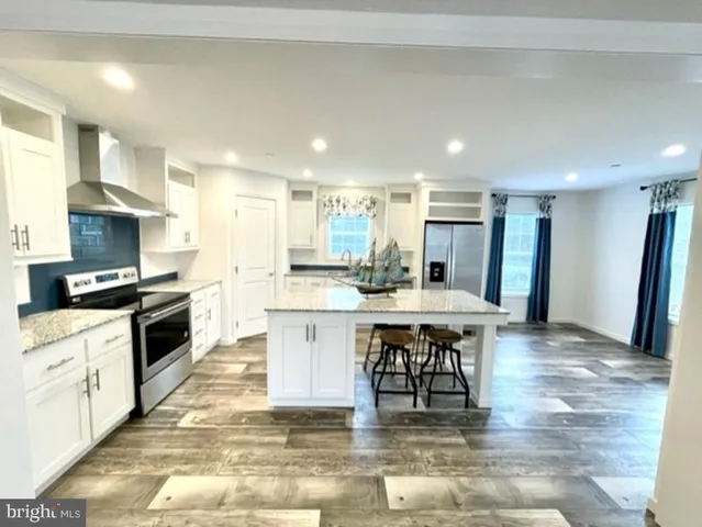 a kitchen with stainless steel appliances granite countertop a stove top oven a sink dishwasher and a refrigerator