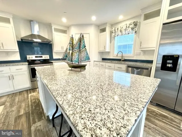a kitchen with stainless steel appliances granite countertop sink stove and refrigerator
