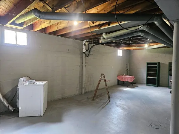 a view of an empty room with wooden roof and stairs