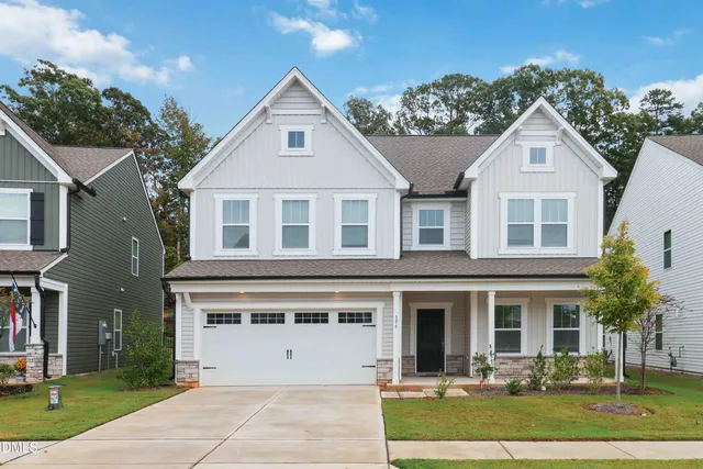 a view of a white house with a yard and plants