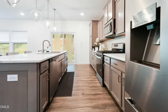 a kitchen with stainless steel appliances a sink stove and refrigerator