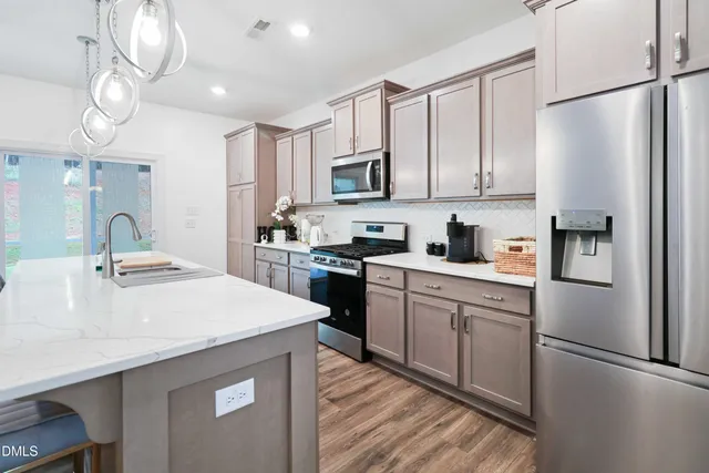 a kitchen with stainless steel appliances a refrigerator sink and cabinets