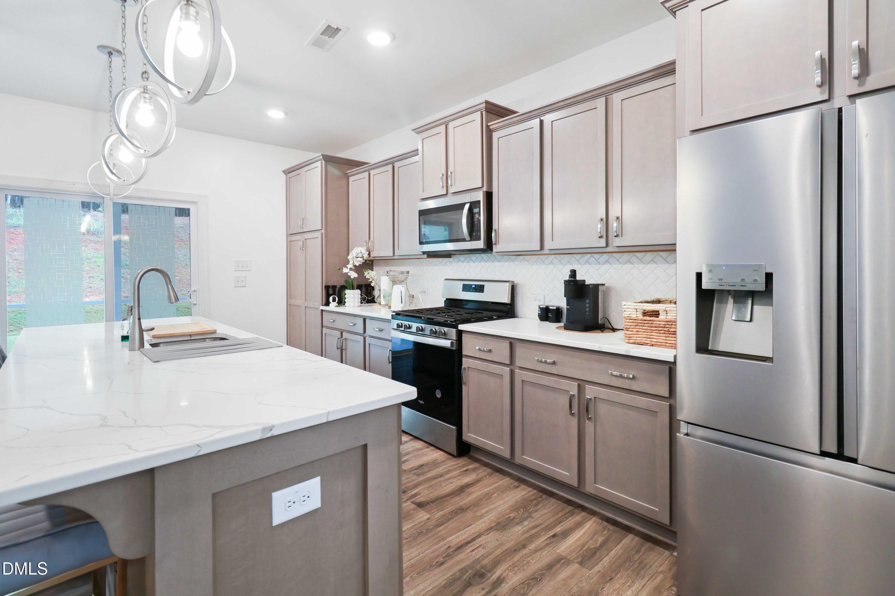 396 Bent Willow Drive Clayton, NC 27527 - Photo 15 of 36 a kitchen with stainless steel appliances a refrigerator sink and cabinets