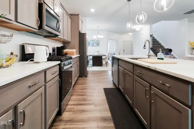 a large kitchen with stainless steel appliances kitchen island a large counter space a sink and cabinets