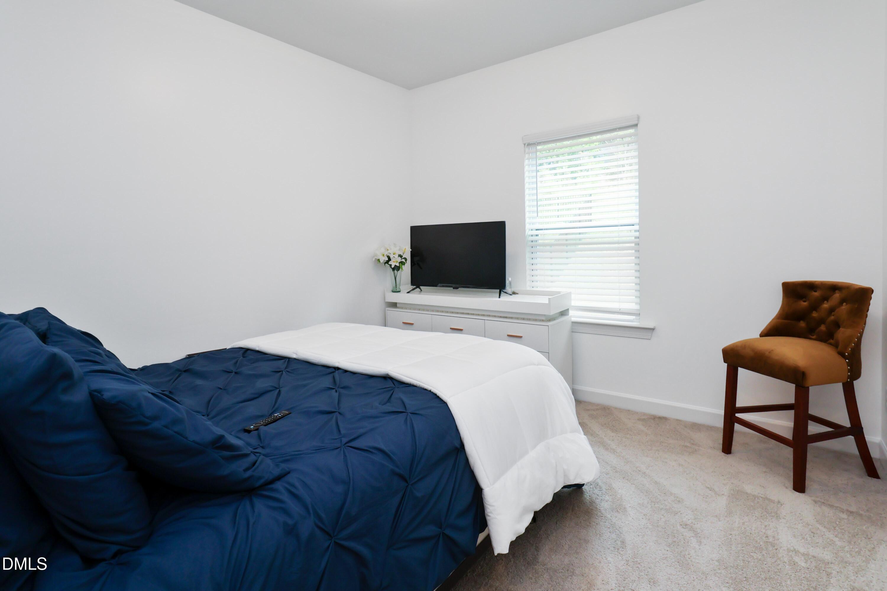 396 Bent Willow Drive Clayton, NC 27527 - Photo 18 of 36 a bedroom with a bed a chair and a window