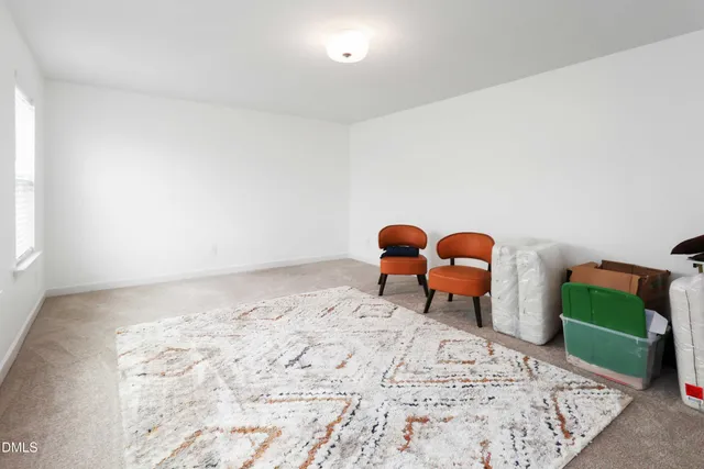 a bedroom with a bed next to a window with chair