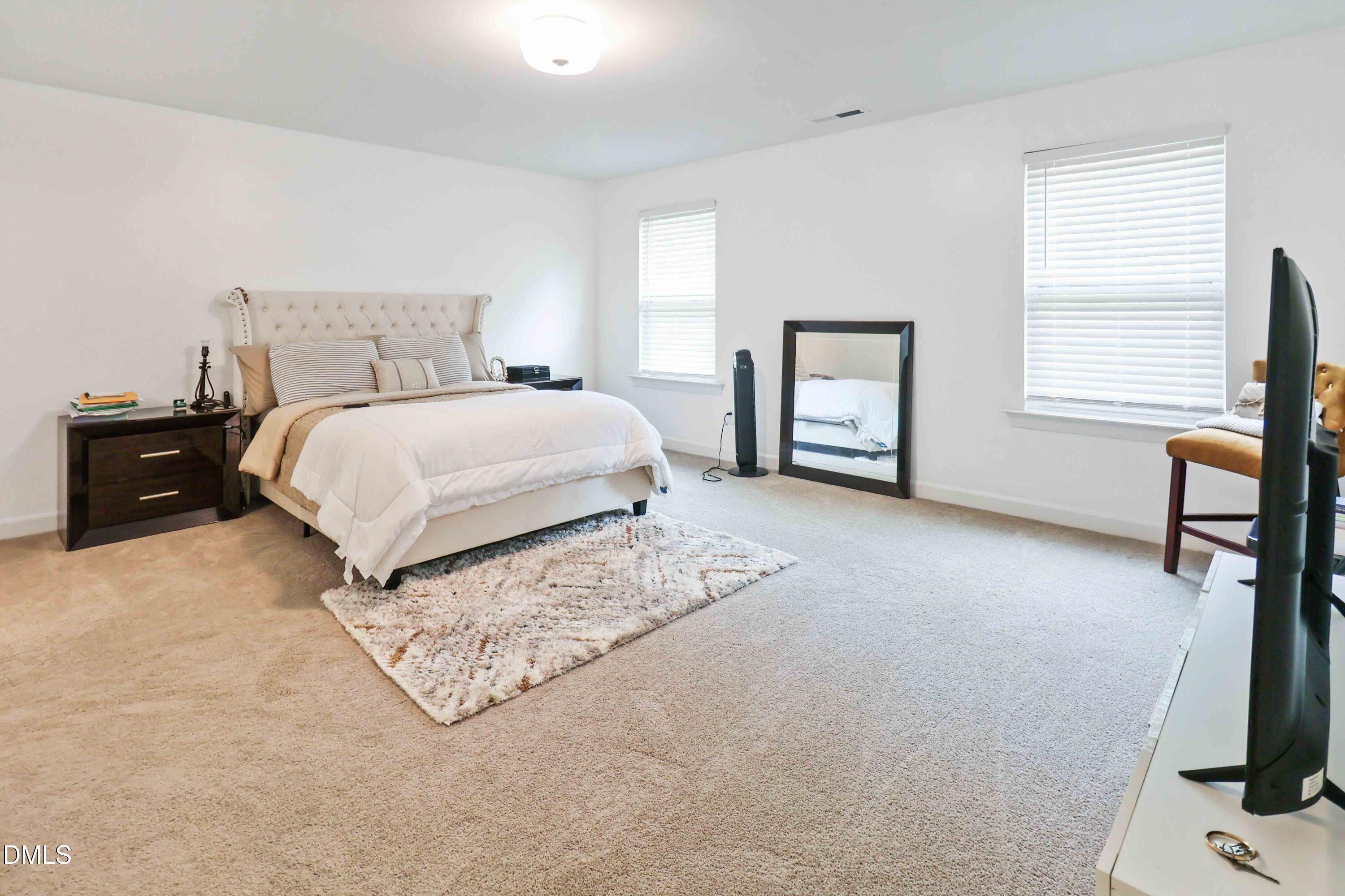 396 Bent Willow Drive Clayton, NC 27527 - Photo 24 of 36 a bedroom with a bed next to a window with chair