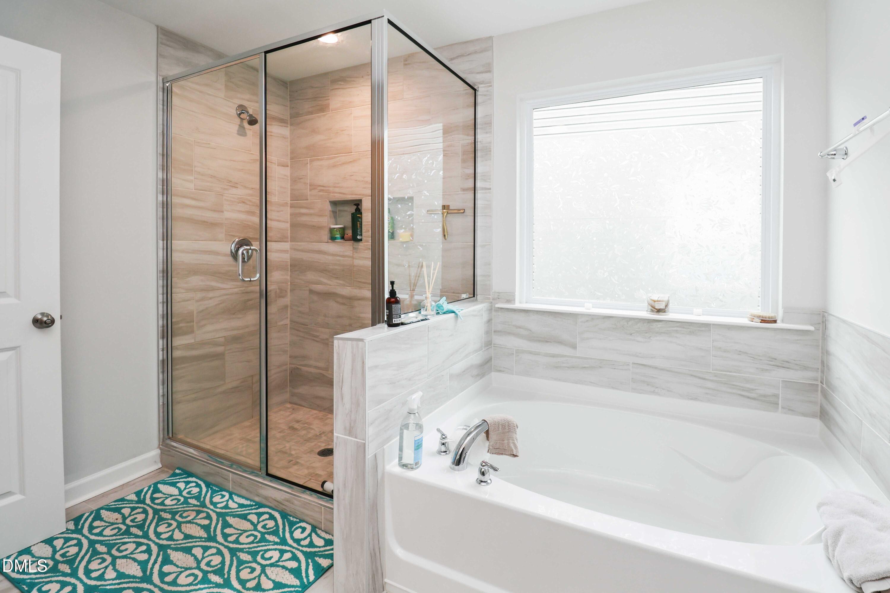 396 Bent Willow Drive Clayton, NC 27527 - Photo 27 of 36 a bathroom with a bathtub and a shower