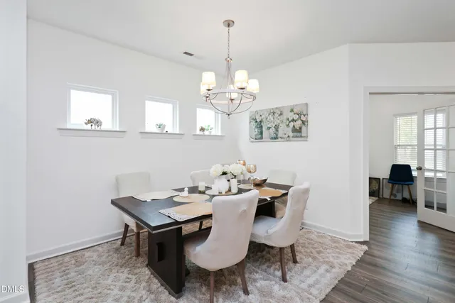 a view of a dining room with furniture wooden floor and a chandelier