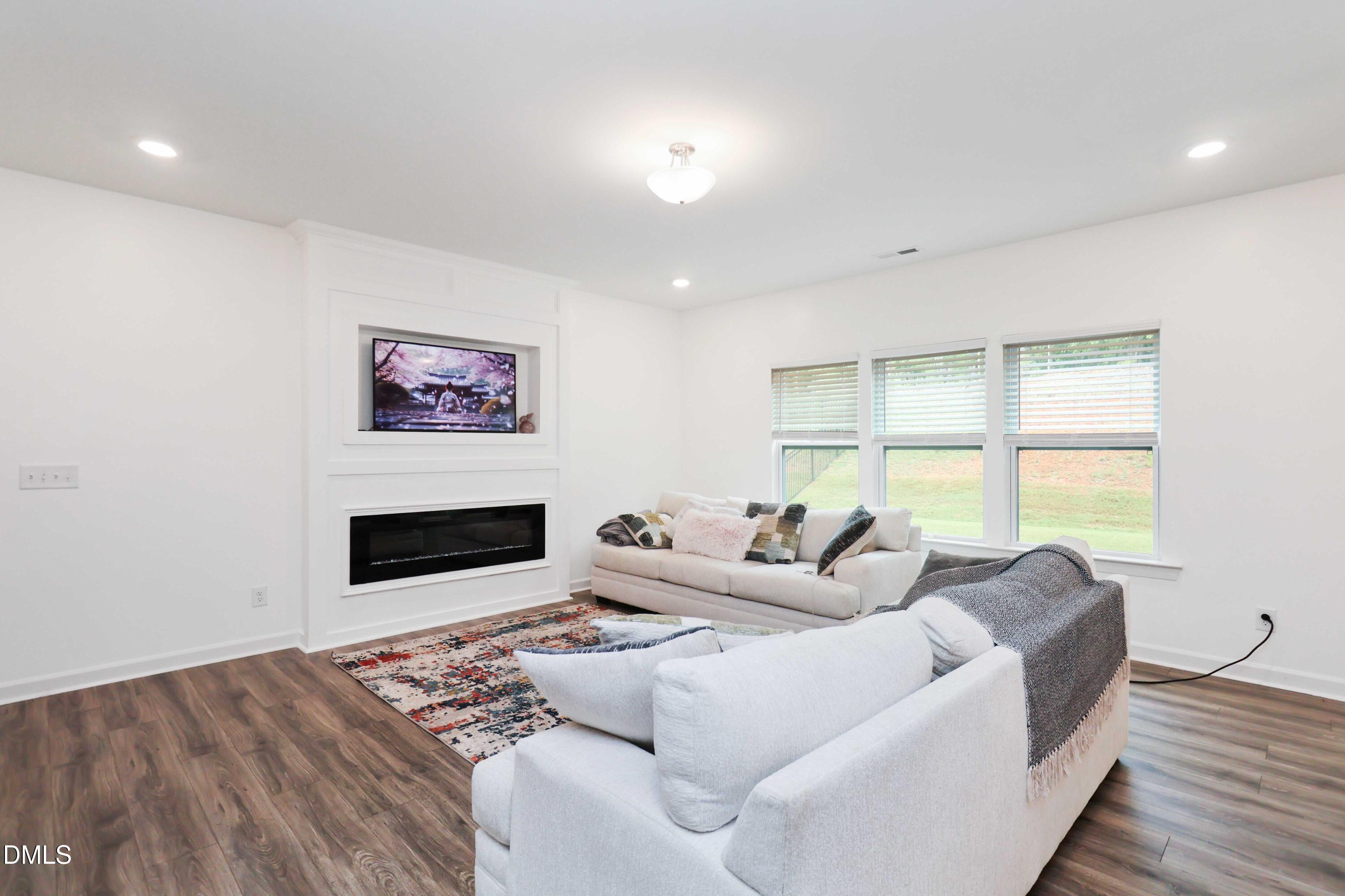 396 Bent Willow Drive Clayton, NC 27527 - Photo 9 of 36 a living room with furniture tv and a large window