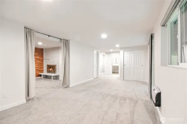 a view of empty room with wooden floor and a window