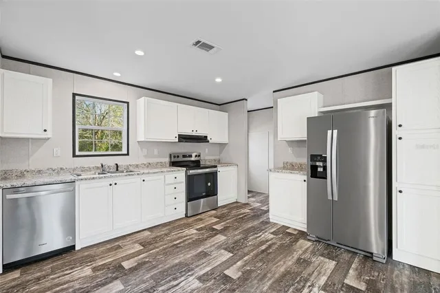 a kitchen with stainless steel appliances granite countertop a refrigerator sink and stove