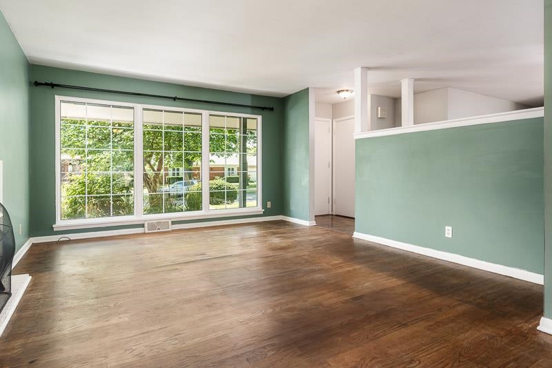 4902 Highcrest Road Rockford, IL 61107 - Photo 9 of 43 a view of an empty room with a window and wooden floor