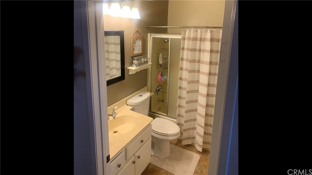 838 Live Oak Place Corona, CA 92882 - Photo 28 of 34 a bathroom with a granite countertop toilet a sink and a shower