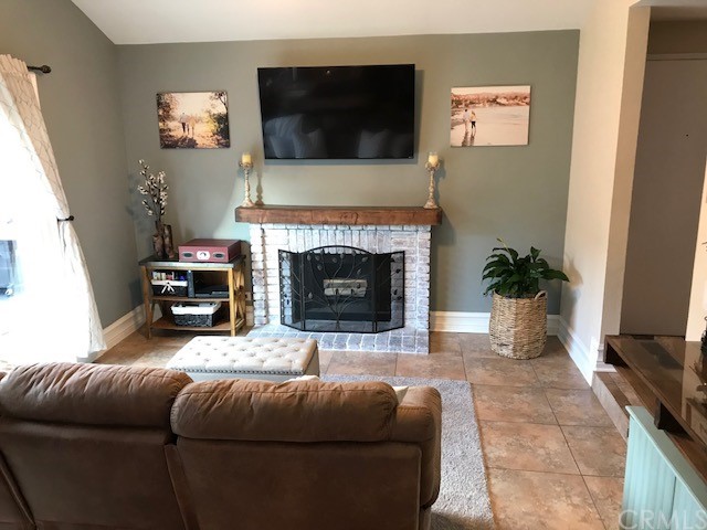 838 Live Oak Place Corona, CA 92882 - Photo 7 of 34 a living room with furniture a flat screen tv and a fireplace