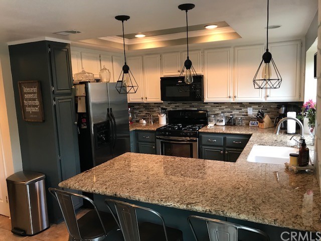 838 Live Oak Place Corona, CA 92882 - Photo 9 of 34 a kitchen with stainless steel appliances kitchen island granite countertop a refrigerator a stove top oven a sink with island and chairs
