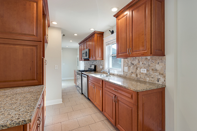 1617 Dundee Road Northbrook, IL 60062 - Photo 6 of 14 a kitchen with stainless steel appliances granite countertop a sink and a stove top oven