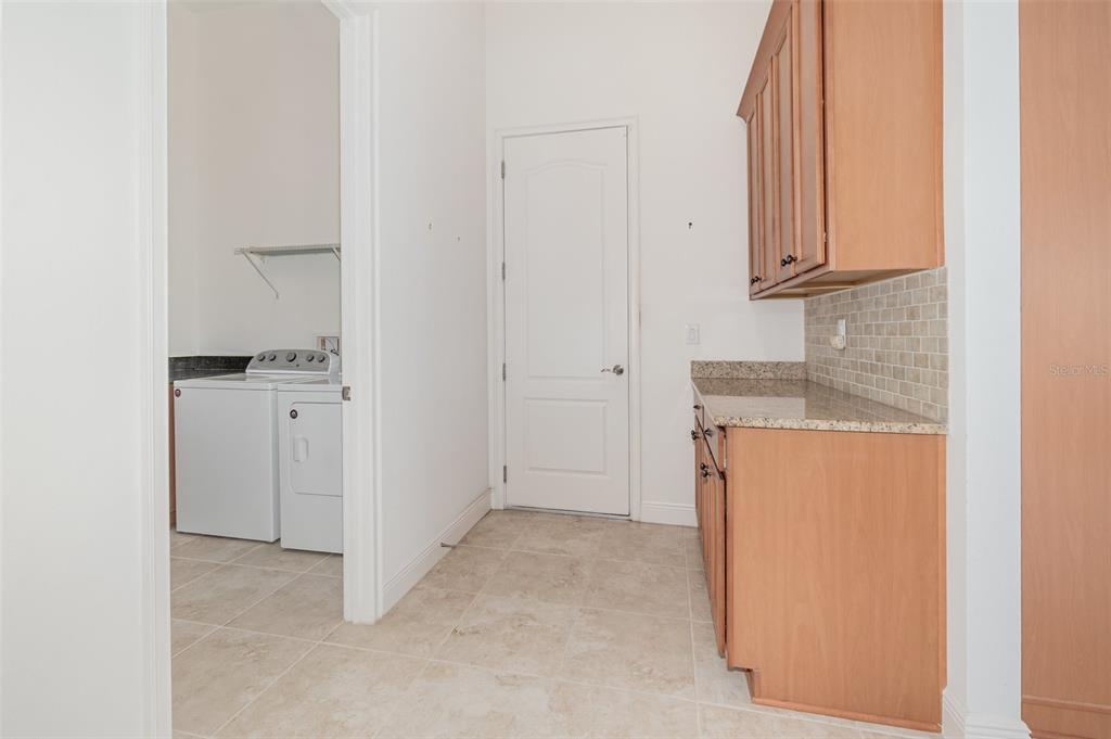 4911 Drawdy Court St. Cloud, FL 34772 - Photo 27 of 37 a view of a kitchen with cabinets and a refrigerator