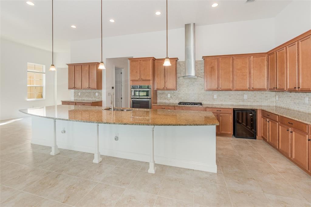 4911 Drawdy Court St. Cloud, FL 34772 - Photo 6 of 37 a kitchen with stainless steel appliances granite countertop a stove a sink and a refrigerator