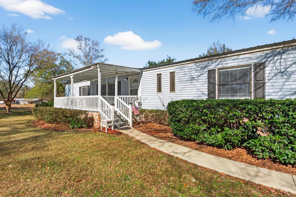 2744 Roy Sikes Road Hilliard, FL 32046 - Photo 2 of 97 a front view of a house with a yard and potted plants