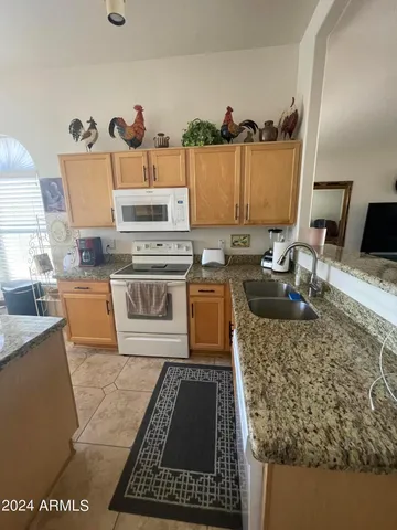 a kitchen with a stove a sink and a wooden cabinets