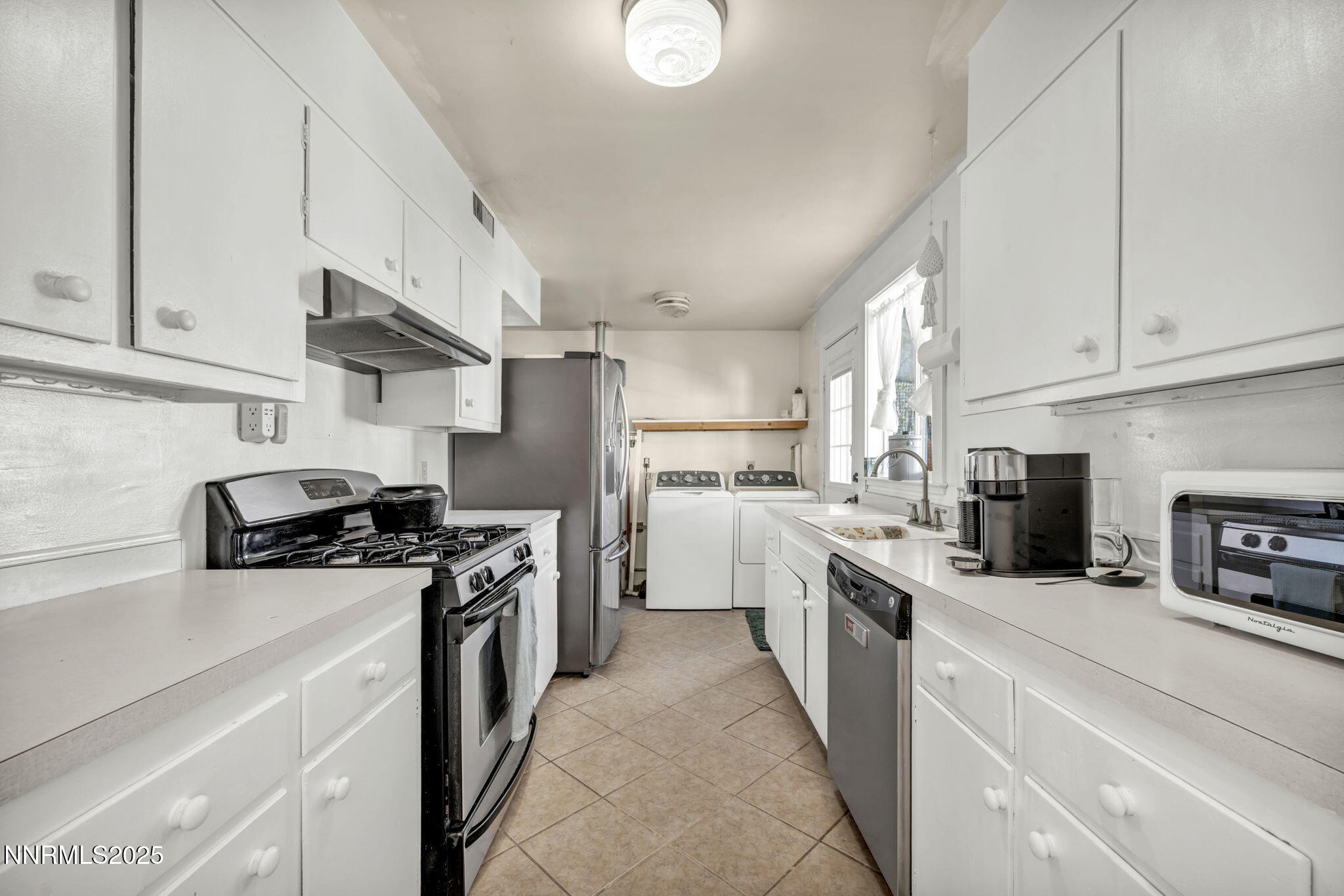 13623 Mt Baldy Street Reno, NV 89506 - Photo 35 of 46 a kitchen with stainless steel appliances granite countertop a sink a stove and a refrigerator