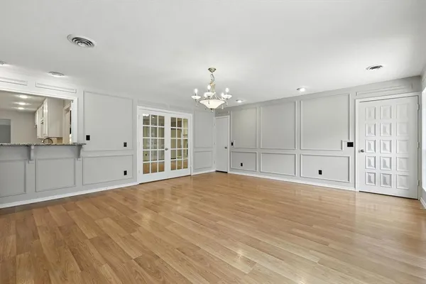 a view of an empty room with window and wooden floor