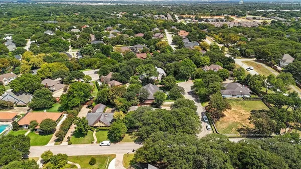 an aerial view of residential house with outdoor space and trees all around