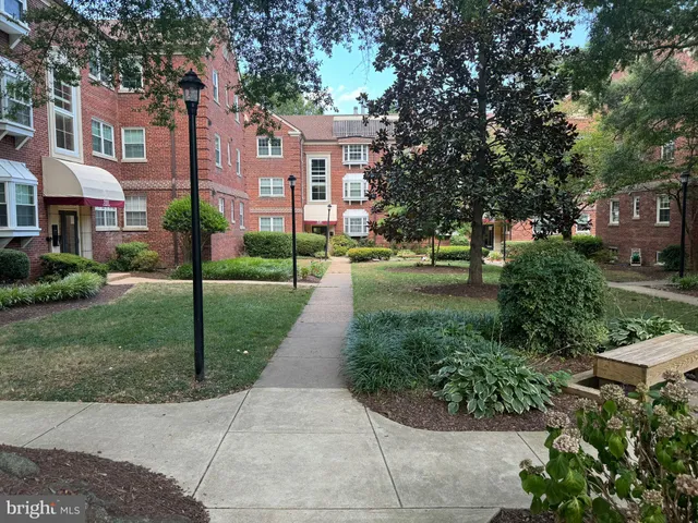 a view of a brick house with a yard and plants
