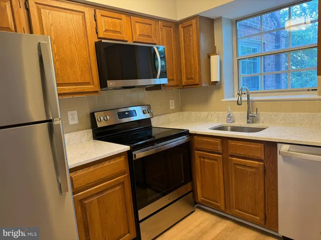a kitchen with stainless steel appliances white cabinets and a refrigerator