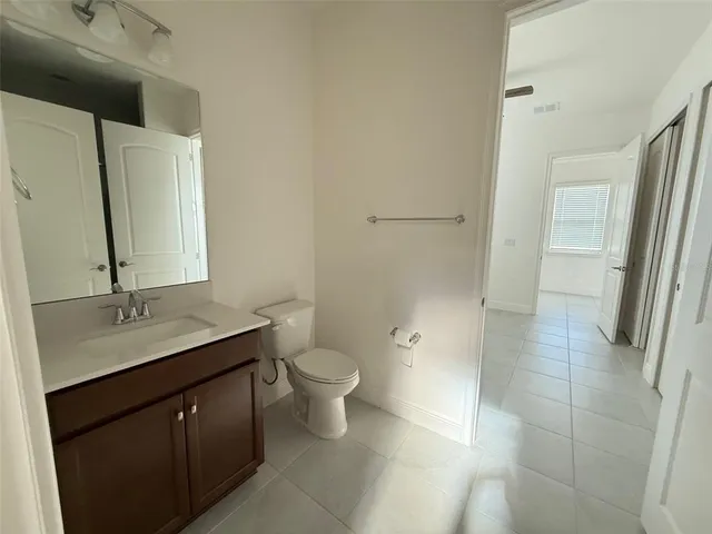 en empty room with windows and ceiling fan