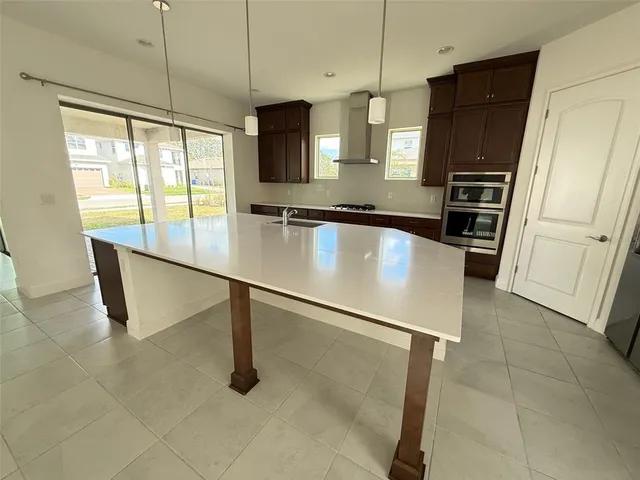 a kitchen with stainless steel appliances granite countertop a sink refrigerator and microwave