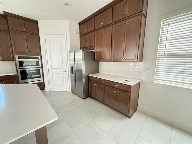 a kitchen with stainless steel appliances a refrigerator and a stove top oven