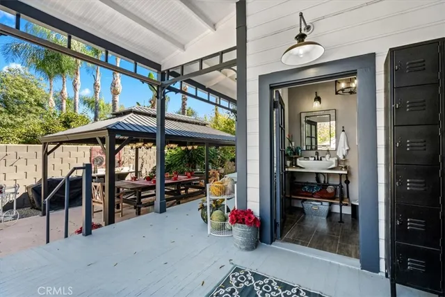 a patio with a table and chairs under an umbrella