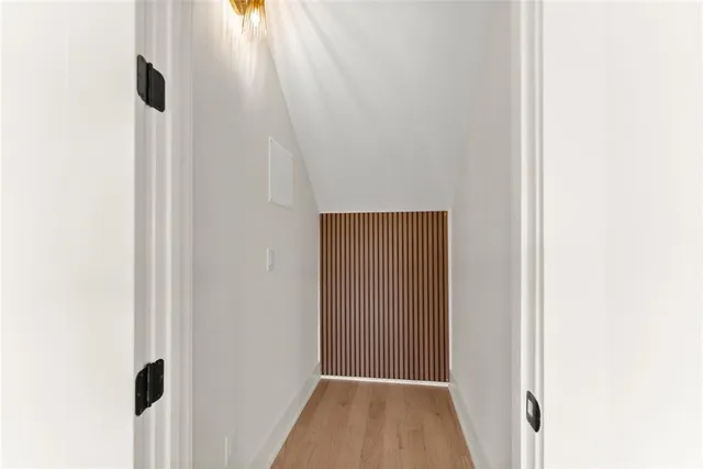 a view of an empty room with chandelier fan